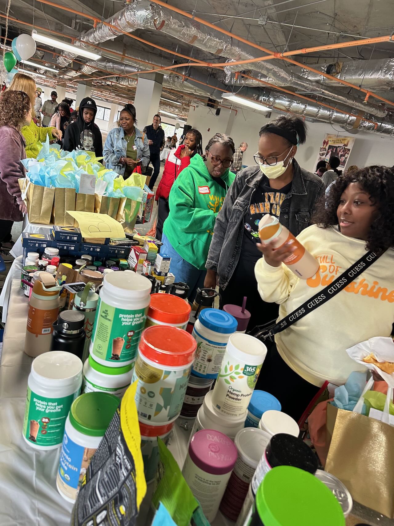 A table stocked with nutrition products, reusable water bottles, and gift bags